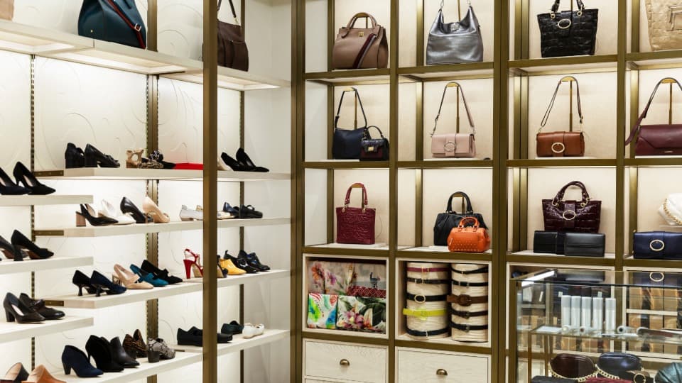 Ein luxuriöses Ankleidezimmer mit Handtaschen in beleuchteten Regalen vor dem Ausräumen und dem Möbeltransport durch DACHSER & KOLB.