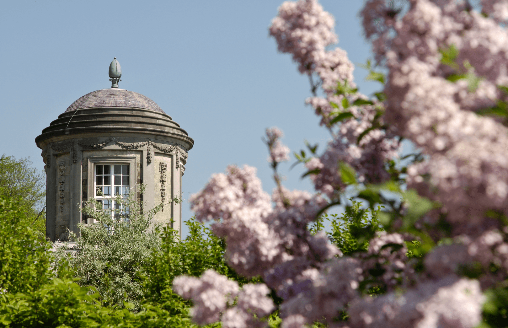 Blühender Garten mit historischem Pavillon als Symbol für das Klima in Belgien