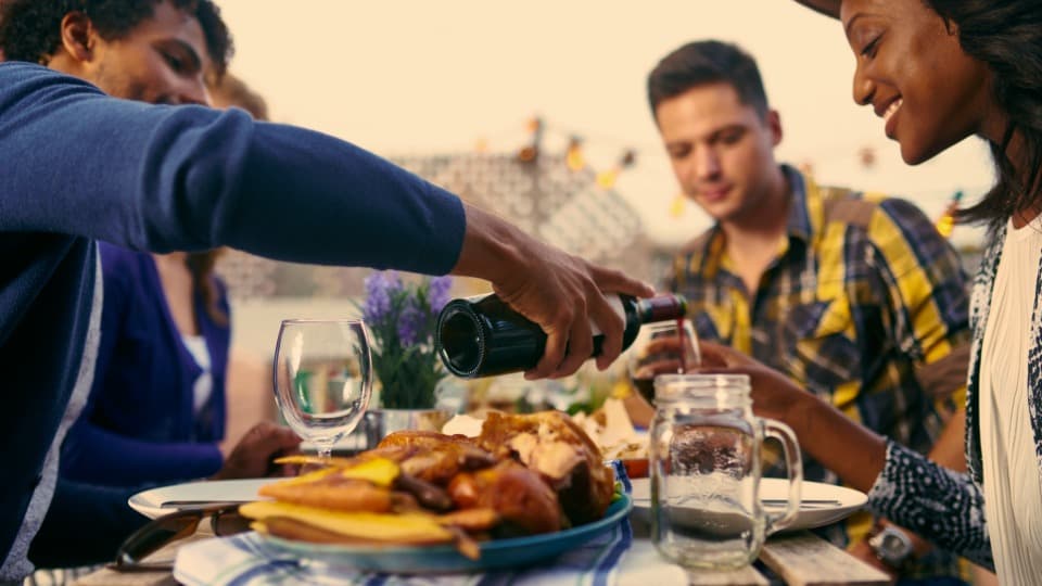 Menschen beim gemeinsamen Essen im Freien als Symbol für Alltag in Frankreich