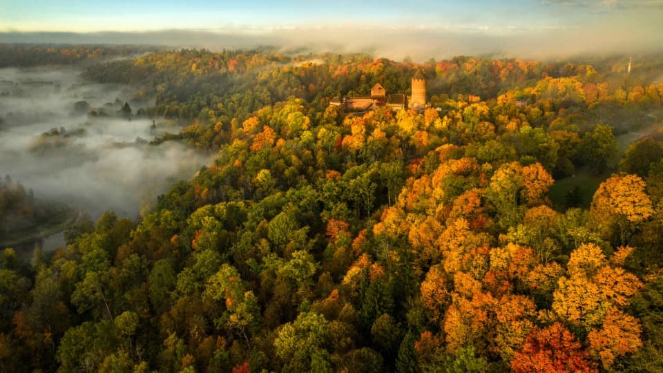 Herbstliche Luftaufnahme der Burg Turaida im Gauja-Nationalpark – ein Symbol für die Verbindung von Geschichte und unberührter Natur in Lettland.