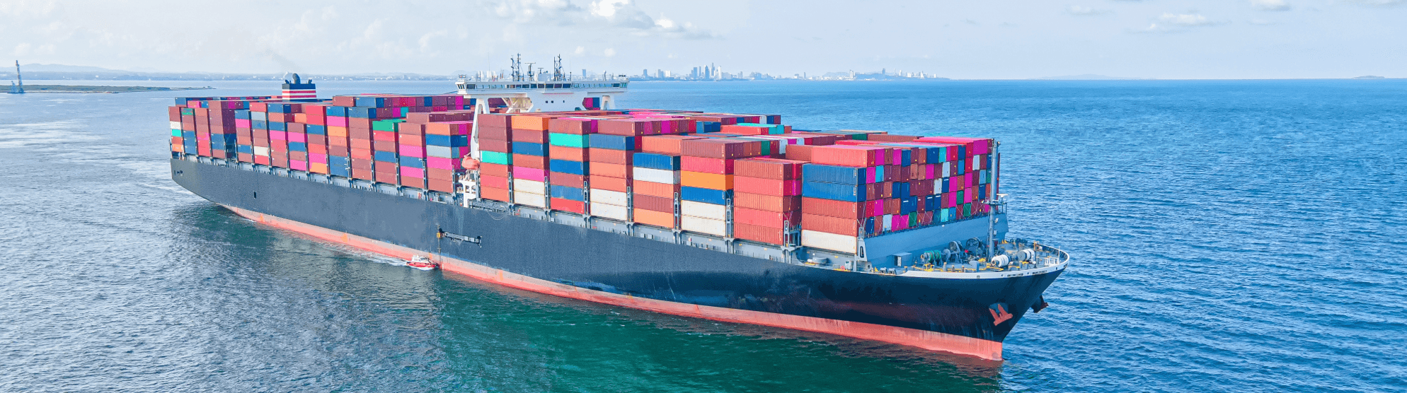 Containerschiff auf See mit bunten Containern, präzise Planung der Estimated Time of Departure (ETD) für reibungslose Logistik.