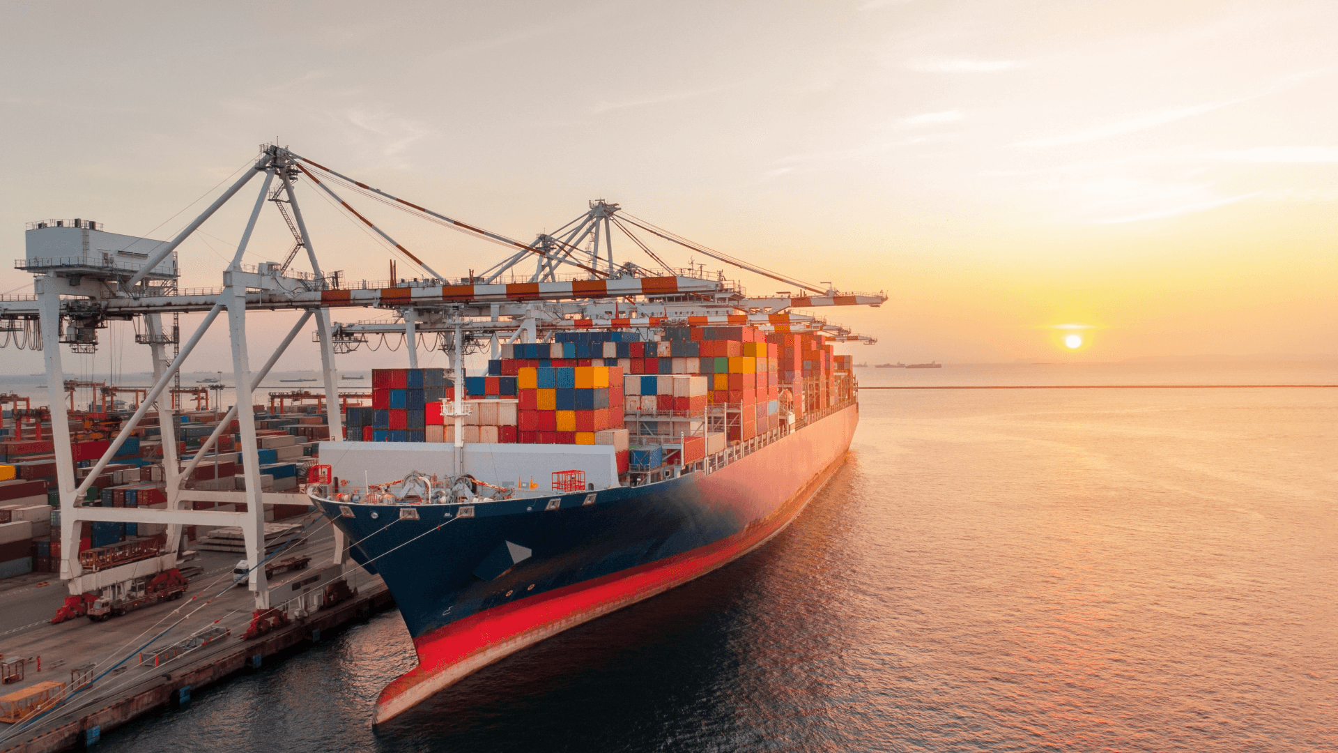 Containerschiff bei Sonnenuntergang im Hafen – Symbolbild für Planung zur Vermeidung von Havarien im Seetransport