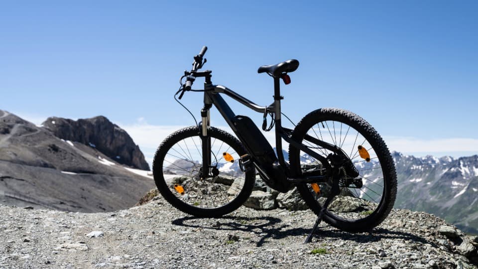 Ein hochwertiges E-Bike mit sichtbarem Akku in den Bergen, vorbereitet für den fachgerechten Umzug und Transport durch DACHSER & KOLB.