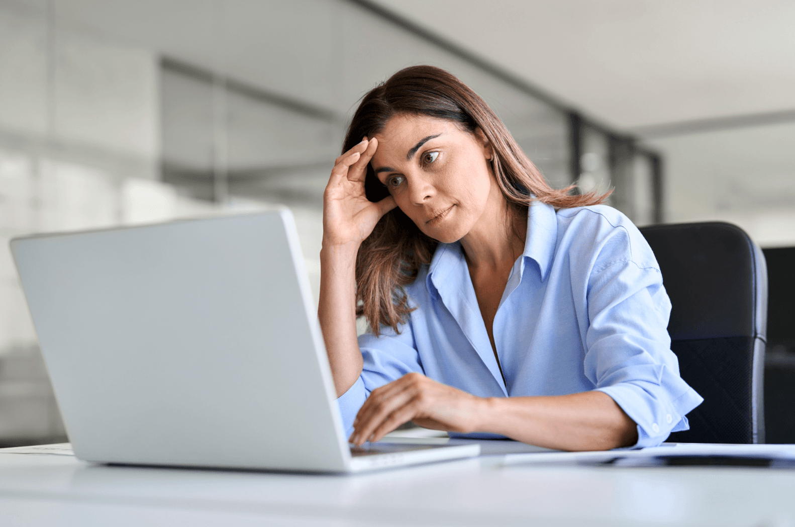 Thoughtful woman at laptop – symbolizes emotional stress during transition to a new phase in life.