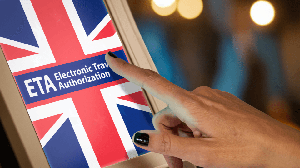 Hand tippt auf Bildschirm mit UK-Flagge und Schrift ETA Electronic Travel Authorization für Einreisegenehmigung
