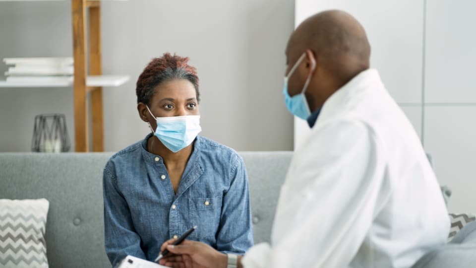 Ein kenianischer Arzt berät eine Patientin in einer Klinik