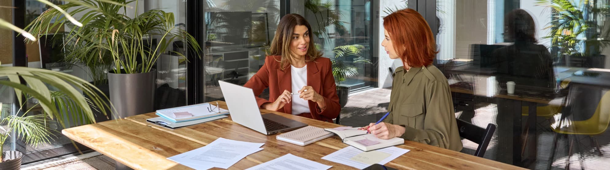 Global Mobility Beratung bei DACHSER und KOLB – Zwei Frauen besprechen die Planung einer Mitarbeiterentsendung am Laptop in einem modernen Büro.