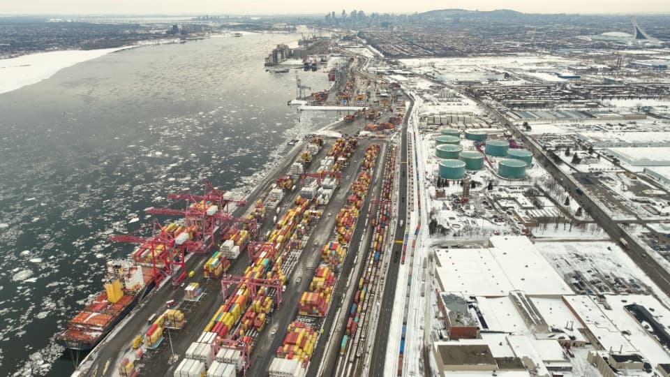 Verschneiter Hafen von Montreal mit Frachtschiff und Bahngleisen für den Inlandtransport beim Kanada-Umzug mit DACHSER & KOLB.