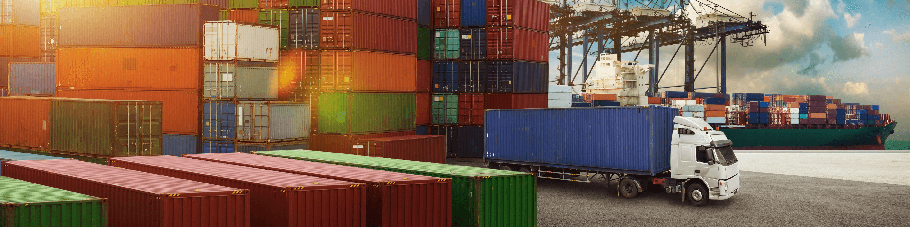 Container im Hafen für internationale Umzüge per LCL, LKW bereit zur Beladung, Schiff im Hintergrund.