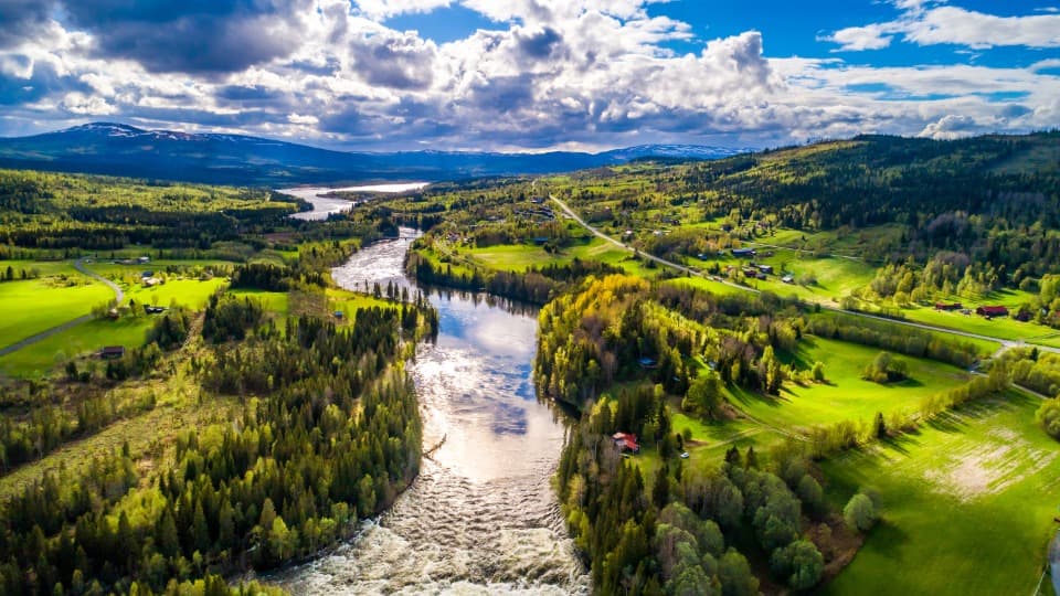 Luftbild einer Landschaft in Schweden im Sommer mit einem Fluss, Wäldern und Wiesen