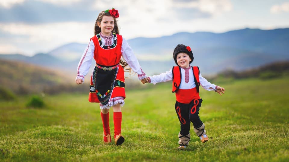 Kinder in traditionellen bulgarischen Trachten – Symbol für die starke kulturelle Identität und das Brauchtum in Bulgarien.