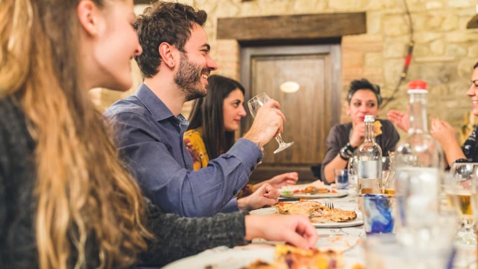Gesellige Runde in einer italienischen Trattoria – Integration und Gemeinschaft durch die italienische Sprache.