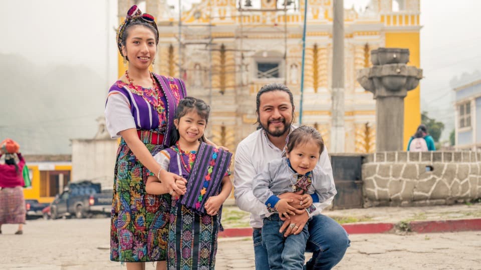 Eine glückliche Familie mit Eltern und zwei Kindern steht auf einem Platz in einer Stadt in Ecuador - Kultur und Bedeutung der Familie in Ecuador