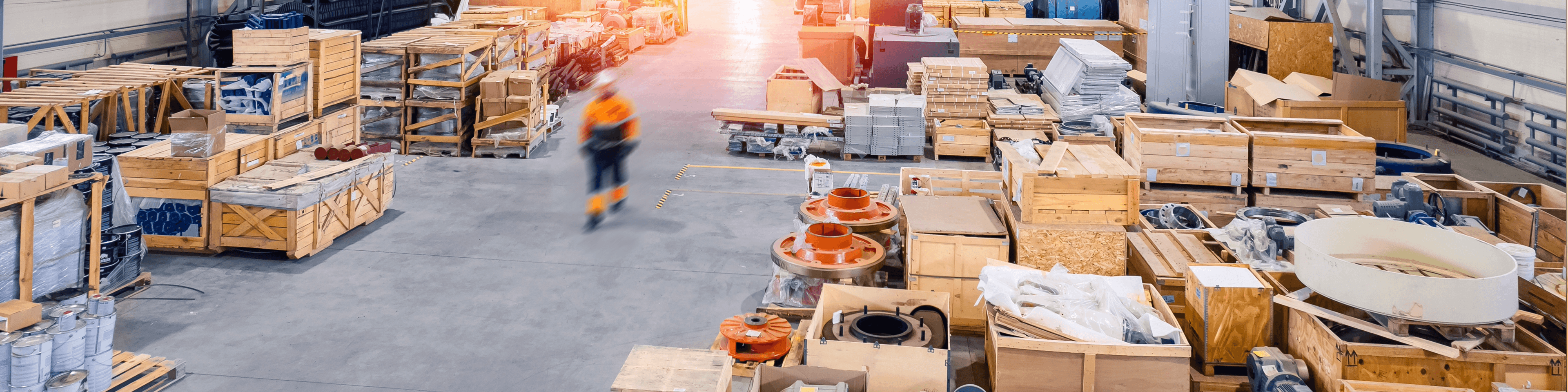 Weitläufiges Lager mit vielen Holzkisten (Crates) und einem Arbeiter in Bewegung. Industrielle Lagerhaltung und Logistik.