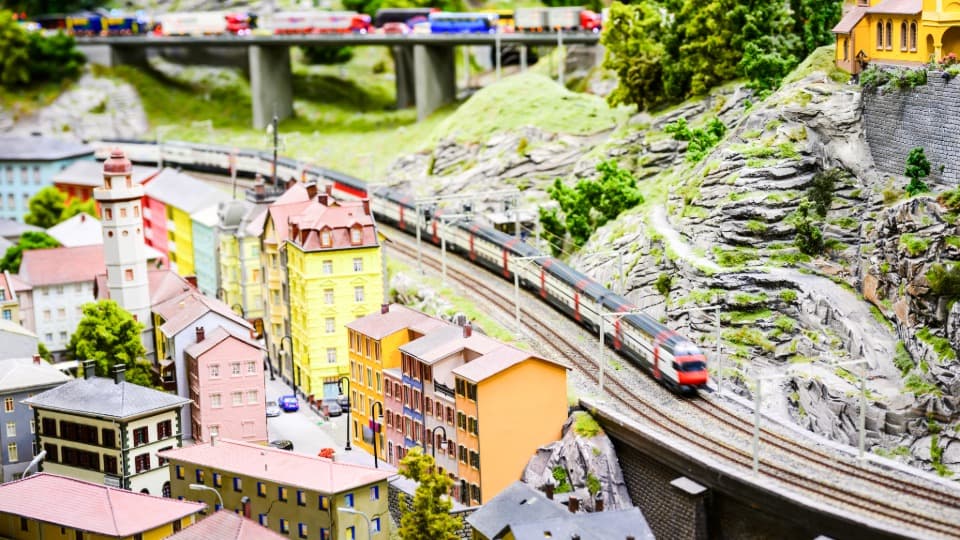 Eine weitläufige Modelleisenbahnanlage mit Stadt und Zügen, deren einzelne Modellbahnmodule für den sicheren Umzug mit DACHSER & KOLB vorbereitet werden.
