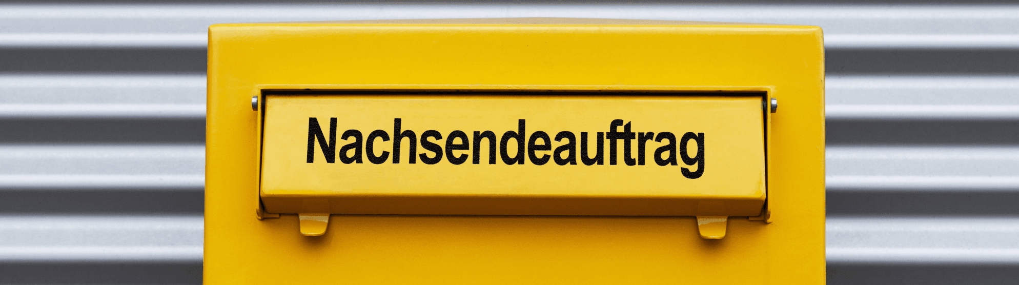 Briefkasten mit gelber Klappe und der Aufschrift „Nachsendeauftrag bei der Post“ für Umzugsservice und Postweiterleitung.