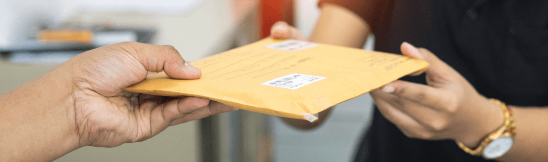 Zwei Personen übergeben sich einen Briefumschlag – Symbolbild für Nachsendeauftrag und Weiterleitung von Post.
