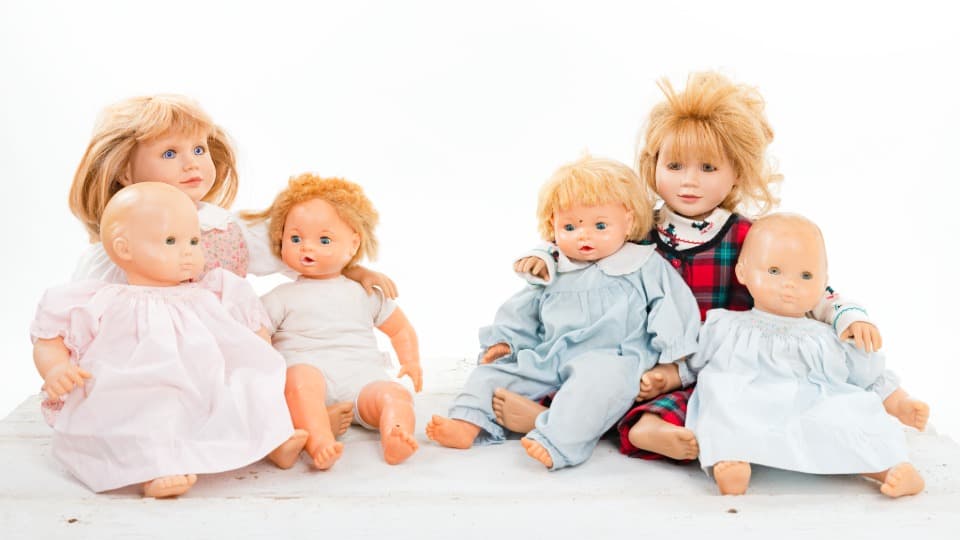 Eine Gruppe verschiedener Sammlerpuppen und Babypuppen vor dem fachgerechten Verpacken für den Umzug mit DACHSER & KOLB.