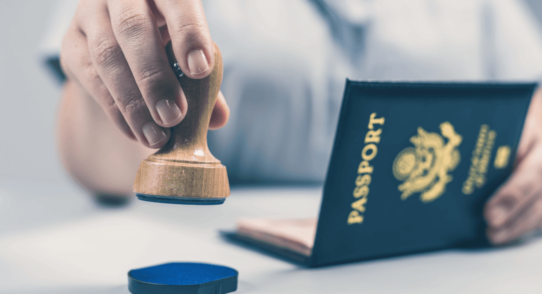 Ein Reisepass wird gestempelt. Symbolisiert die Formalitäten und Einreise-Organisation beim Relocation Service für Privatpersonen.