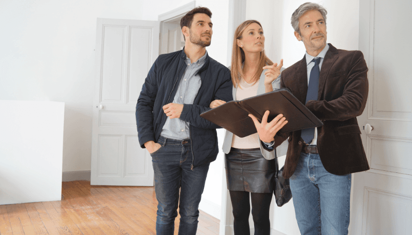 Couple at apartment viewing with agent – money-saving moving tip: use free on-site inspection services