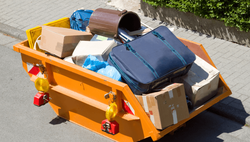 Bulky waste container with suitcases and boxes – proper disposal and recycling during a move