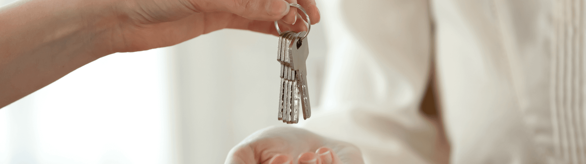 Übergabe von Wohnungsschlüsseln – symbolisch für Einzug und Tipps für die erste eigene Wohnung