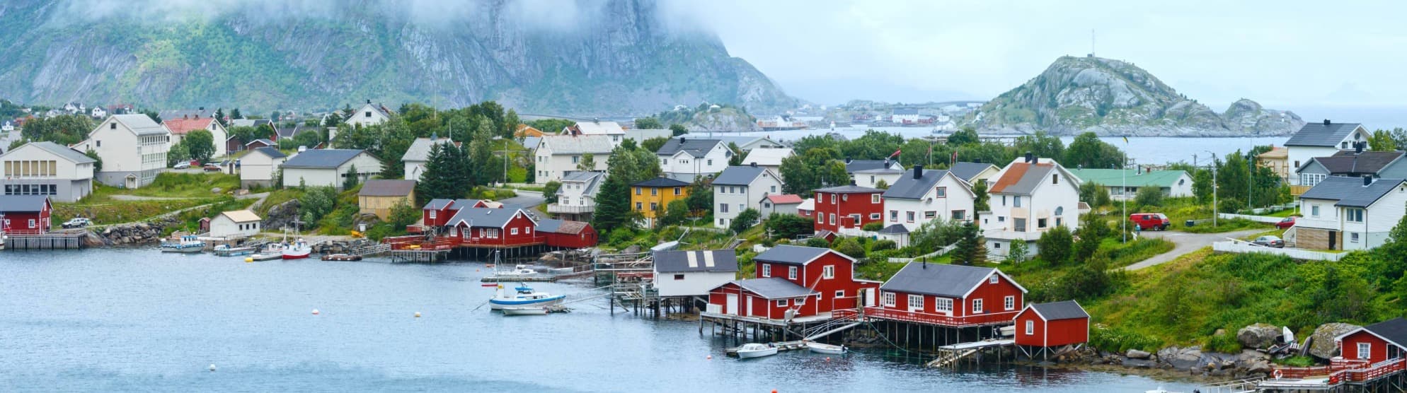 Küstenort in Norwegen mit Häusern am Wasser – Symbolbild für Anforderungen beim Umzug mit Tieren nach Norwegen.