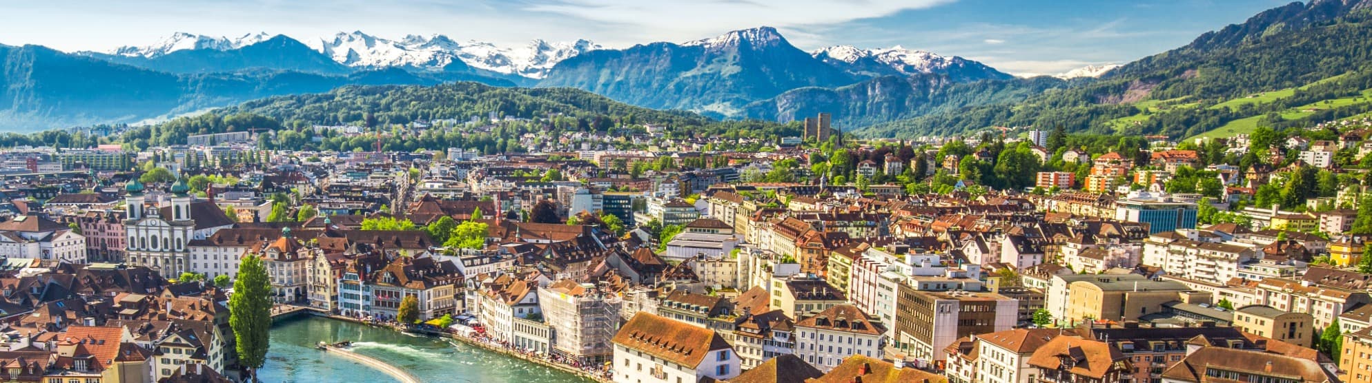 Panorama der Stadt Luzern mit der Jesuitenkirche und den Schweizer Alpen im Hintergrund für den Auslandsumzug in die Schweiz mit DACHSER & KOLB.