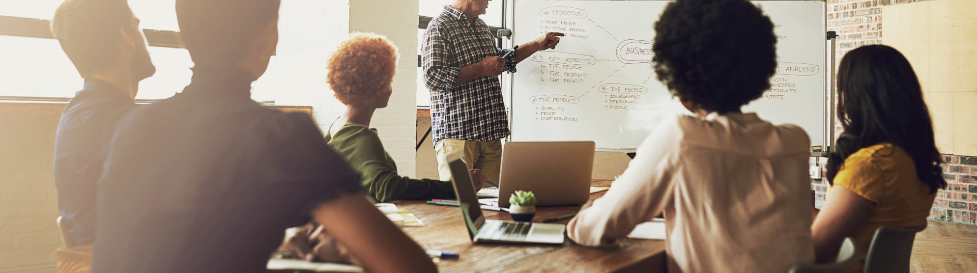 Team bei einer Besprechung mit Whiteboard – Symbolbild für Tipps und Wissen im Umzugs-ABC