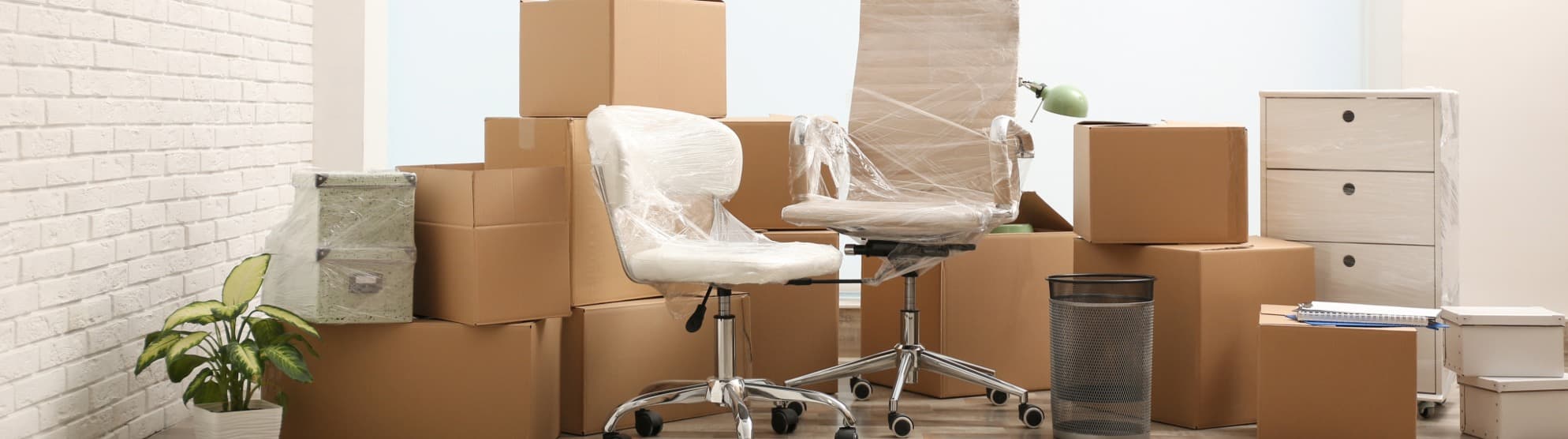 Eingepackte Bürostühle und strukturierte Umzugskartons für die professionelle Umzugslogistik und den Firmenumzug mit DACHSER & KOLB.