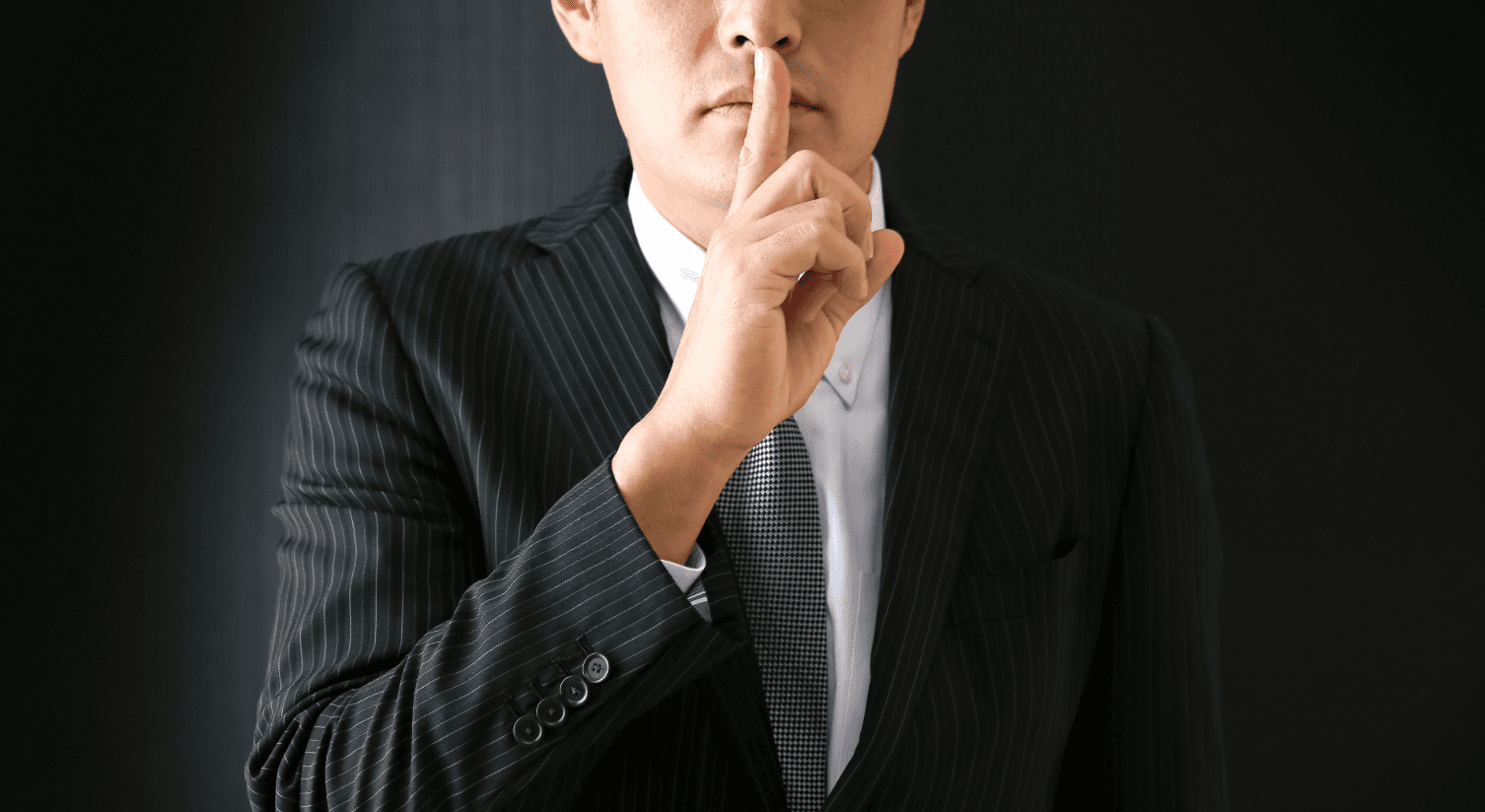 Discretion during a VIP relocation for high-profile personalities – man signaling confidentiality with finger on lips