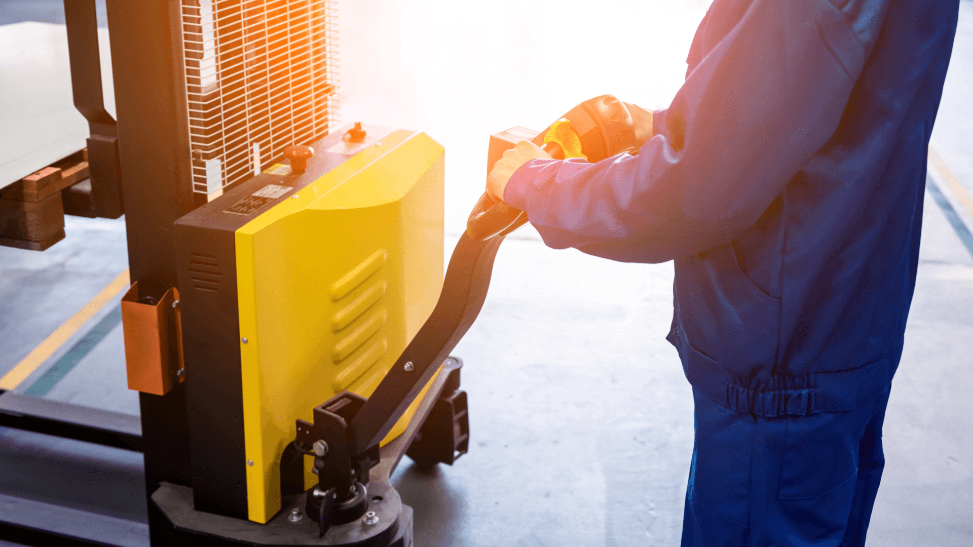 Mitarbeiter bewegt Palette mit Elektrohublifter – Vorbereitung für LCL (Teilcontainerladung) im Lager