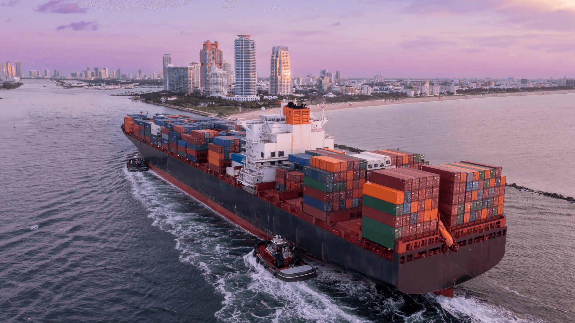 Containerschiff mit Schleppern fährt in einen Stadthafen ein – Experten für reibungslose Seefracht-Umzüge weltweit.