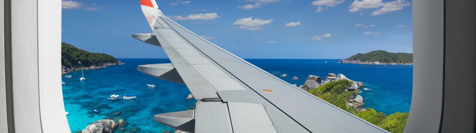 View from airplane window of Thailand’s coast – symbolic image for customs regulations when moving to Thailand.
