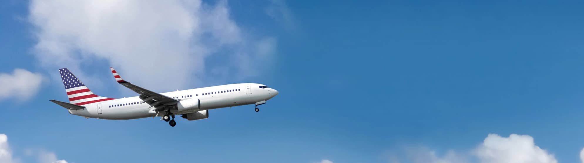 Flugzeug mit US-Flagge am Heck im Anflug – Symbol für Zollvorgaben und Einfuhrbestimmungen beim USA-Umzug.