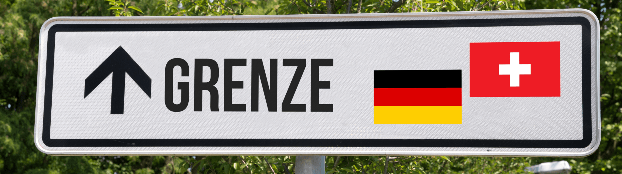 Border sign labeled “Grenze” with arrow and German and Swiss flags, symbol for customs in Switzerland