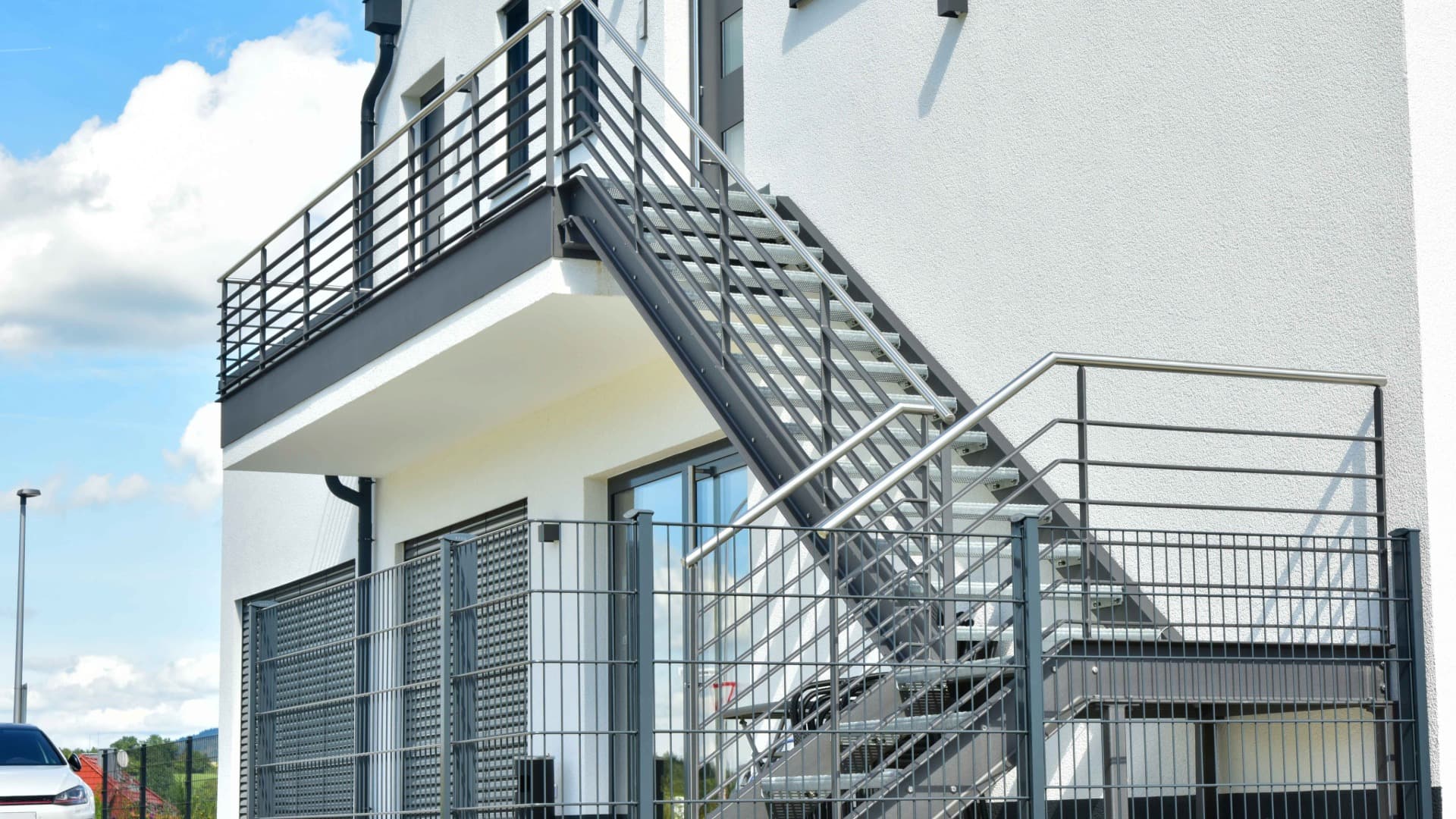 Außentreppe mit Geländer am Gebäude – langer Abtrageweg über mehrere Treppenstufen bis zum Eingang.