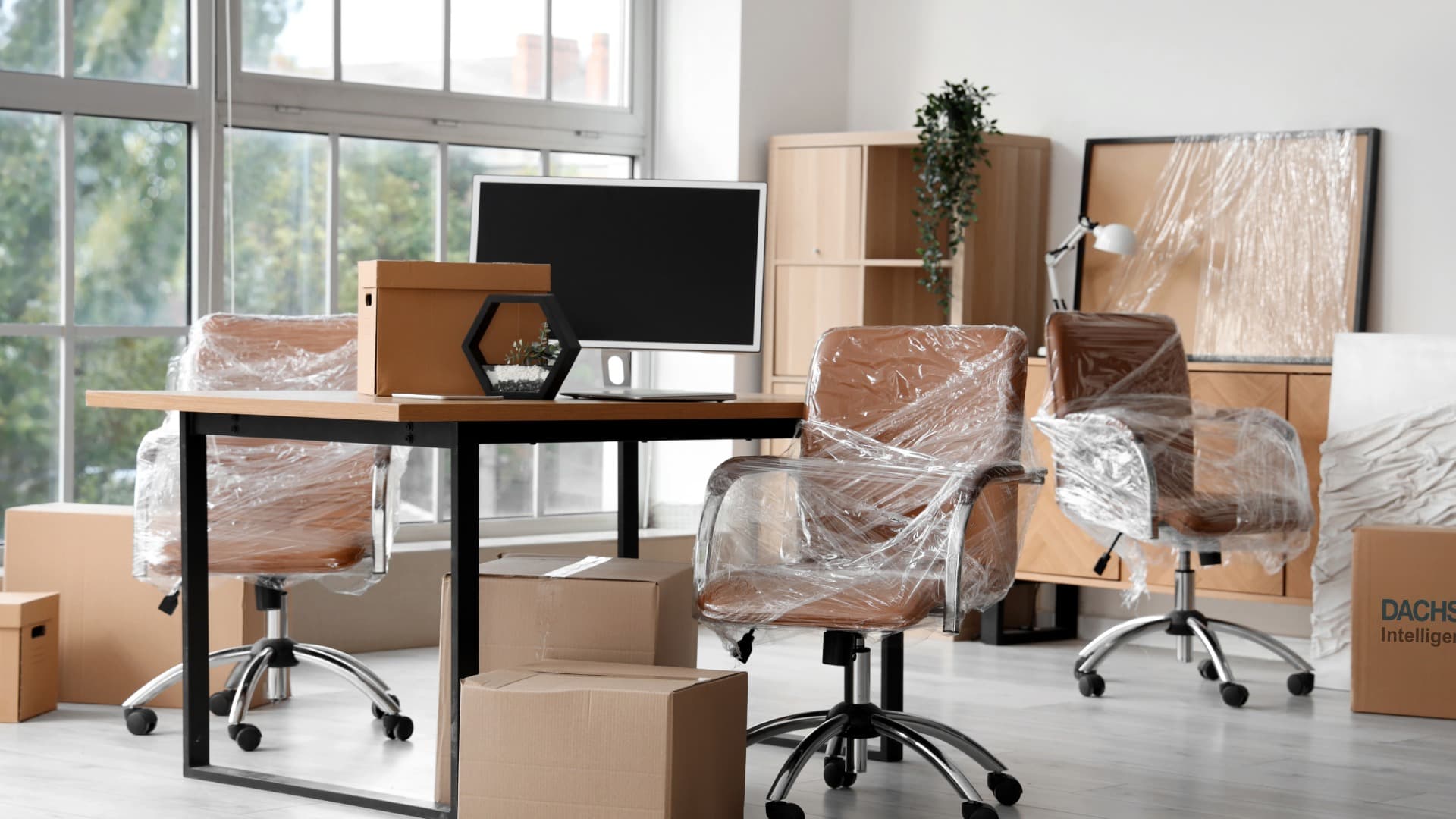 Verpackte Büromöbel und Kartons nach Anlieferung von Packmaterial für den Umzug.