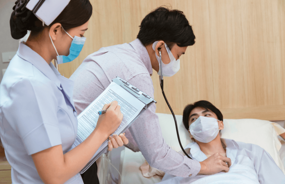 Arzt und Pflegekraft untersuchen einen Patienten im Krankenhaus