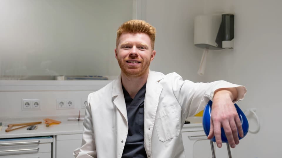 Ein irischer Arzt in einer modernen Praxis als Symbol für die medizinische Versorgung und Krankenversicherung in Irland.