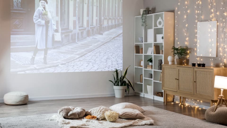 Ein vollständiges Heimkino-Setup mit Projektion an der Wand und gemütlicher Einrichtung als Beispiel für die Umzugsvorbereitung mit DACHSER & KOLB.