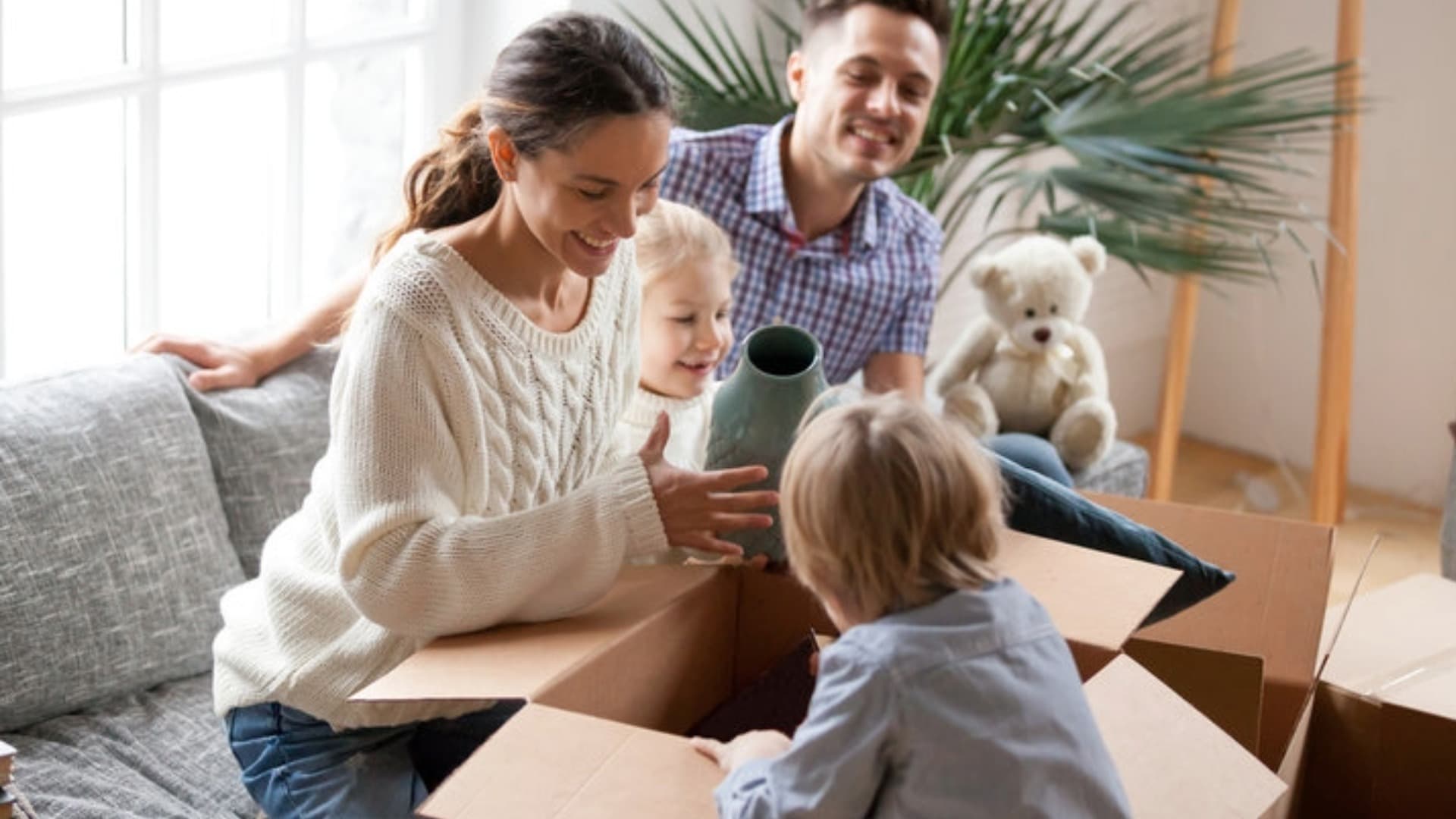Familie mit Kind und Hund packt Umzugskartons – Symbol für stressfreie Organisation und Transportdauer beim Umzug.