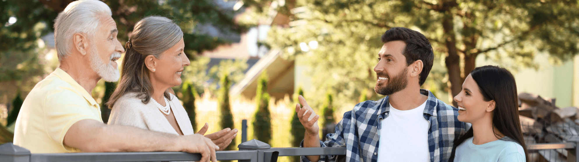 Two couples of different ages having a friendly conversation outdoors. Getting to know the neighborhood after moving.