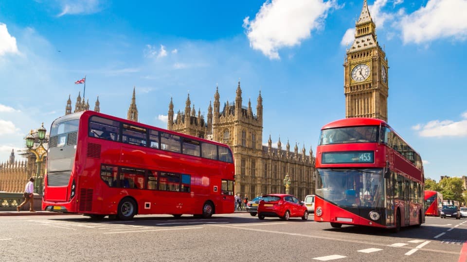 Rote Doppeldeckerbusse vor dem Big Ben – Hinweis zur Aufmerksamkeit in öffentlichen Verkehrsmitteln und an Hotspots in London.