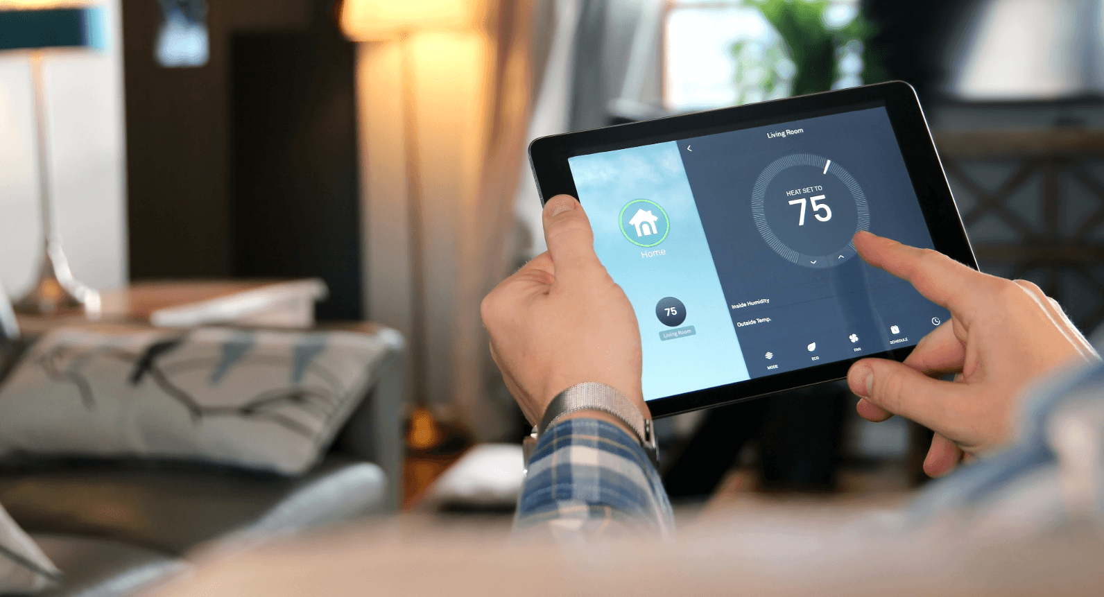 Smart-Home-Technologien: Person regelt Raumtemperatur bequem per Tablet für barrierefreies und komfortables Wohnen