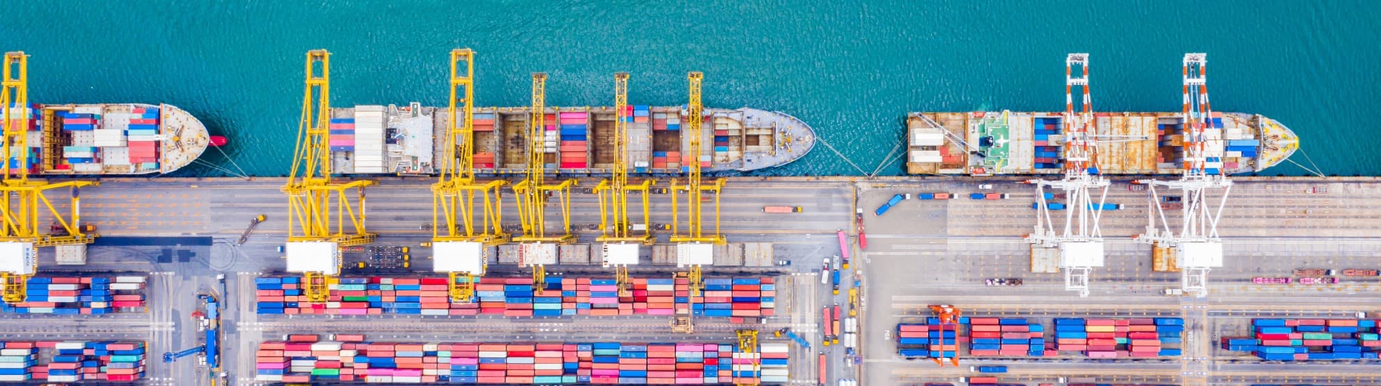 Luftaufnahme eines Containerterminals mit Frachtschiffen und Kränen beim Be- und Entladen – Terminal Handling Charges.
