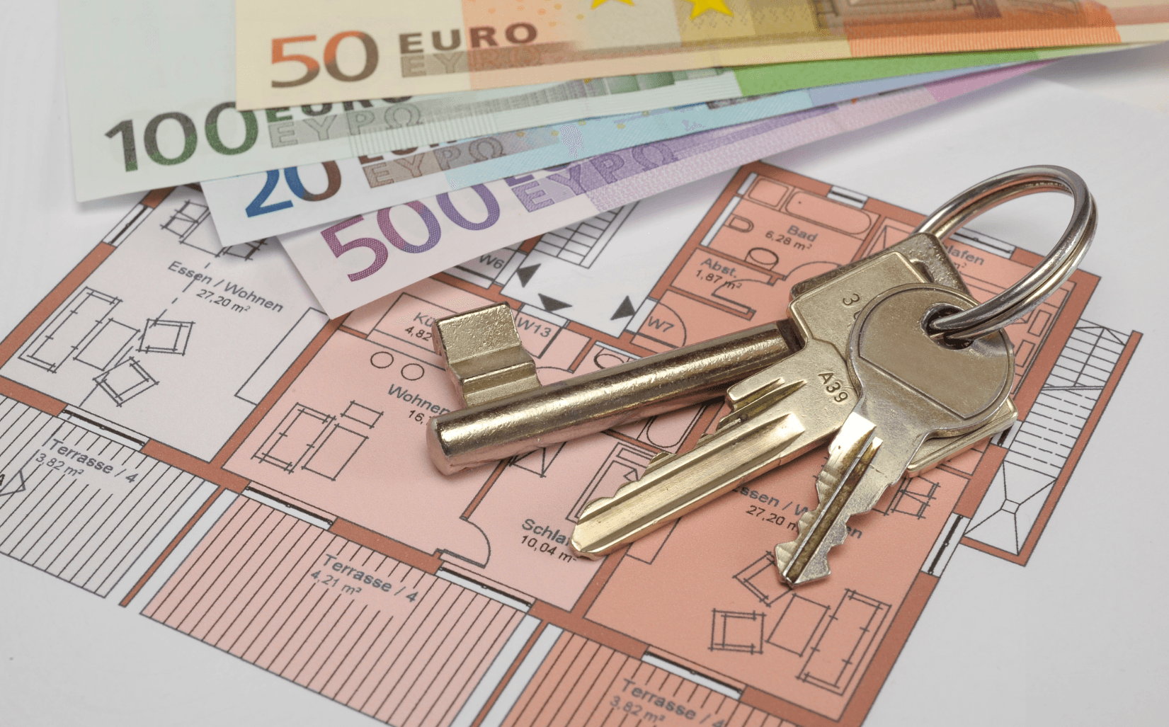 Keys and banknotes on apartment layout – symbolic image of financial aspects of apartment handover